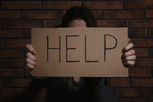 woman holding up help sign